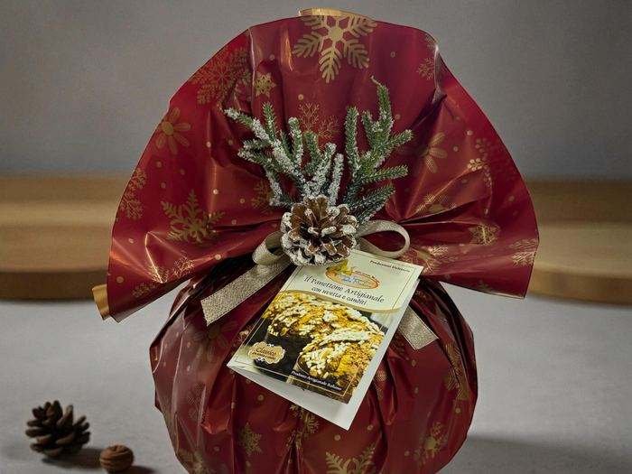Panettone confezionato in carta rossa con fiocco oro