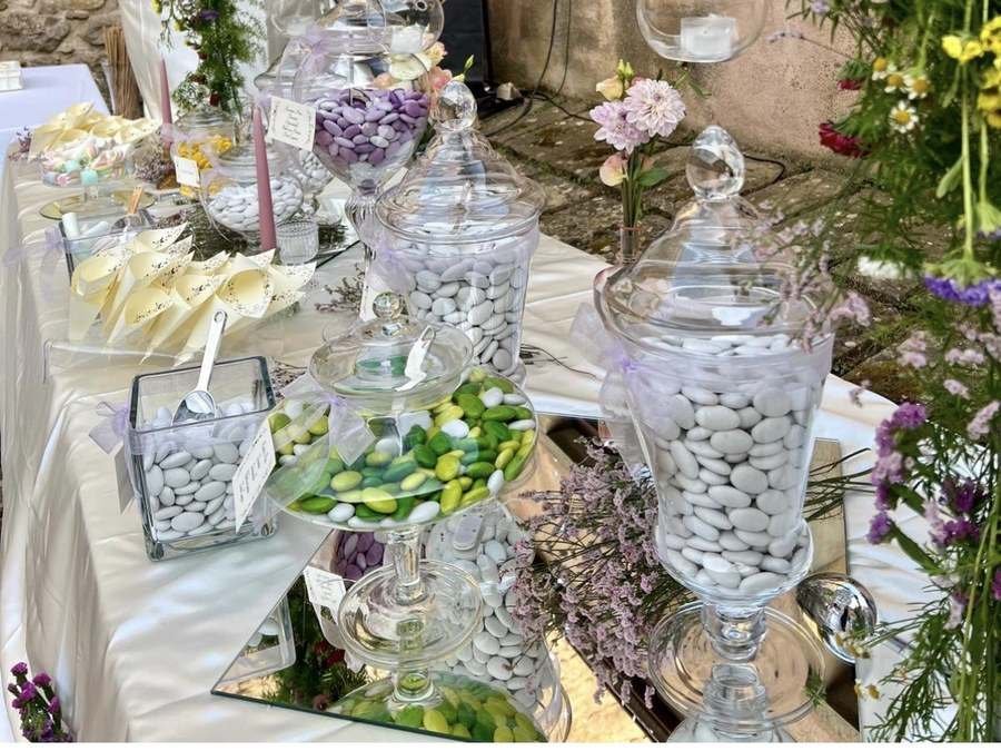 Confettata allestita per un matrimonio, con giare di confetti e arco di fiori