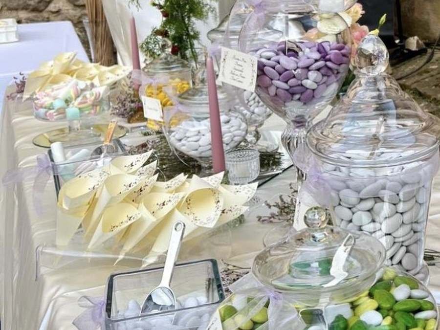 Giare di confetti e coni personalizzati su tavolo confettata per matrimonio